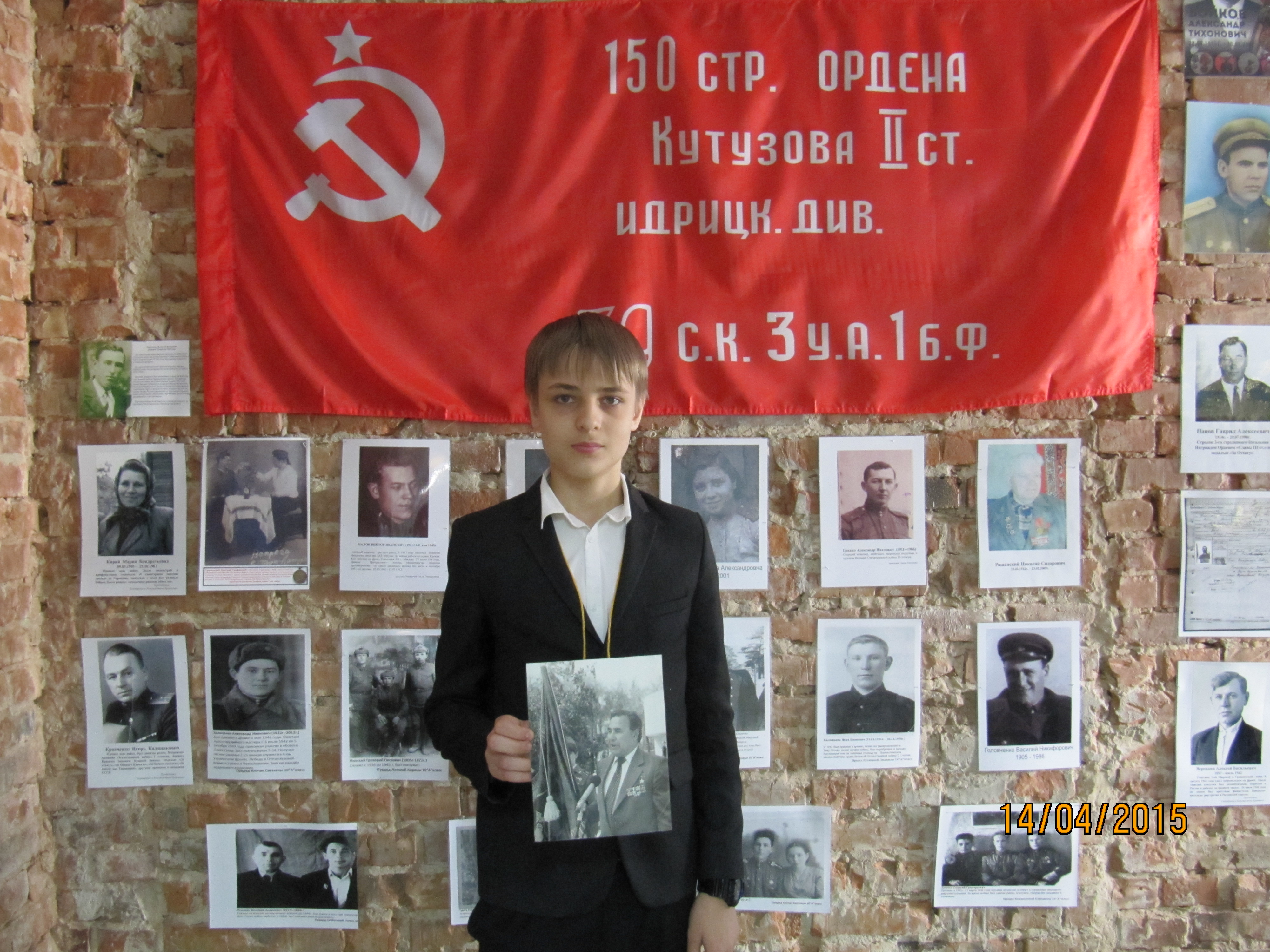 Ученик гимназии держит в руках фотографию своего деда - Героя Советского Союза